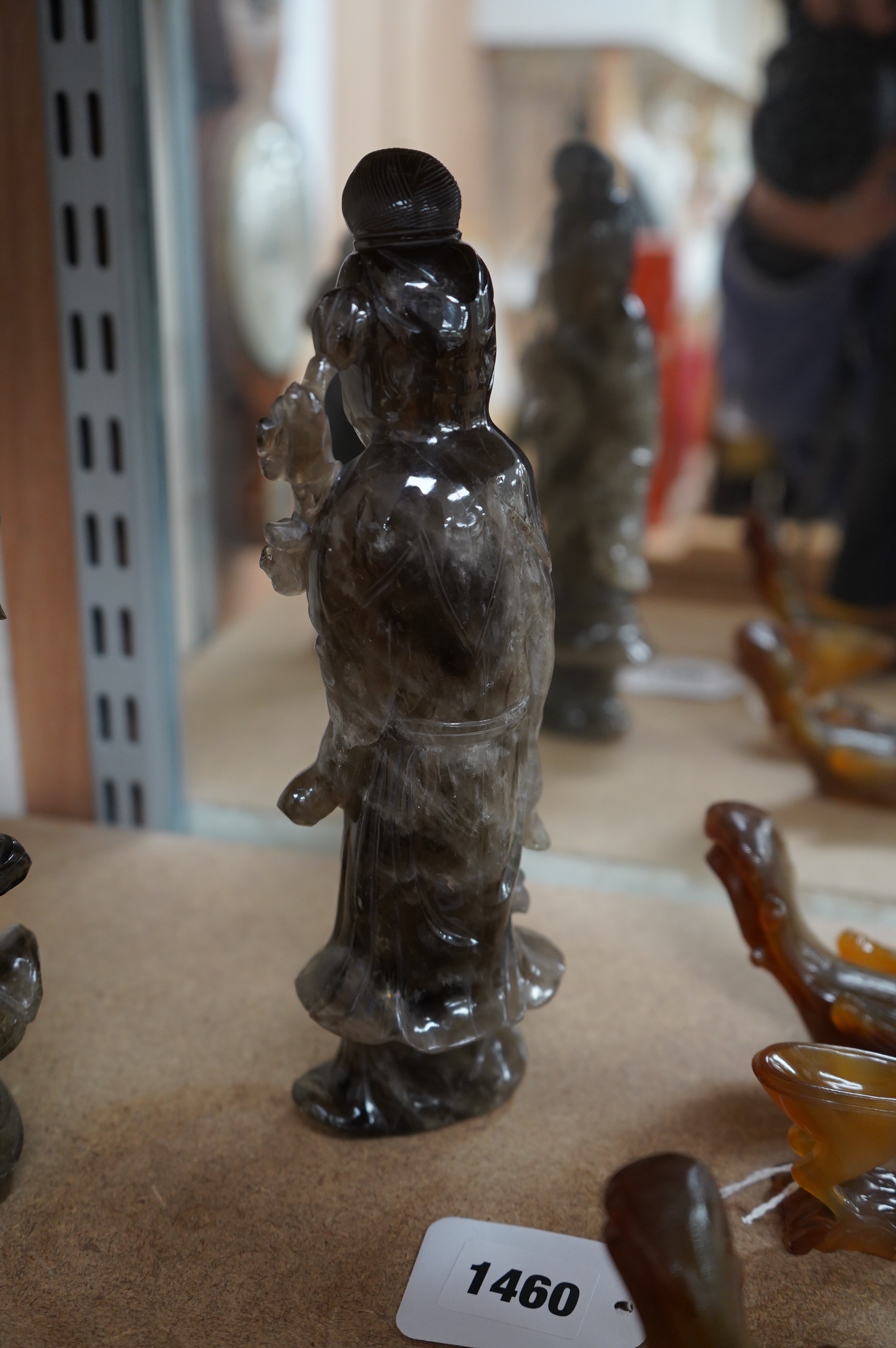 A 19th century Chinese smoky quartz figure of a standing lady holding a fruiting branch, 23cm high. Condition - chips to flowers and under edges of garment